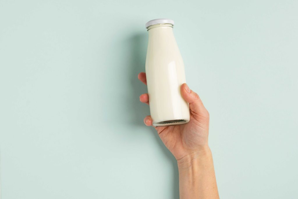 Bouteille remplie de lait de vache dans une main